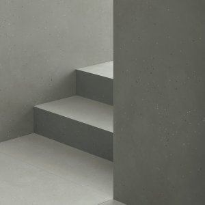 Primavera Nero の床と Grigio の壁、革張りチェア